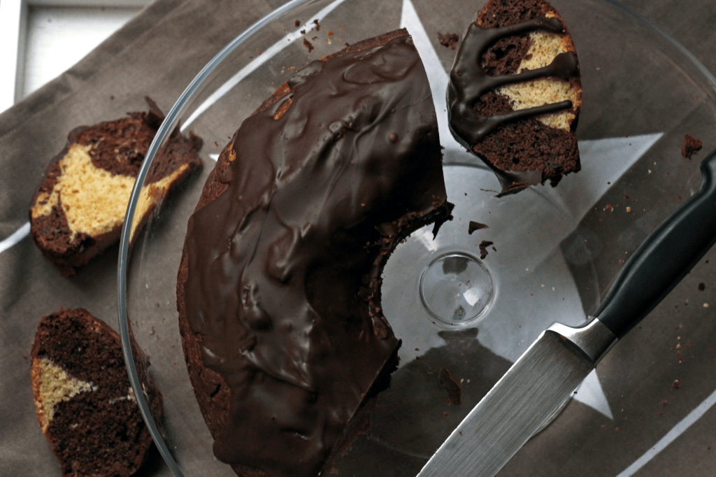 Marmorkuchen und -stücke mit Glasur auf einer Glasplatte mit Messer